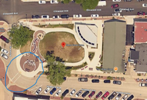 Screenshot 2026-07-15 084221 - OccuPaws Aerial map view of a small park and plaza at the corner of Aurora Street and Hubbard Avenue, with a blue circle outlining a circular seating area near a curved walkway.